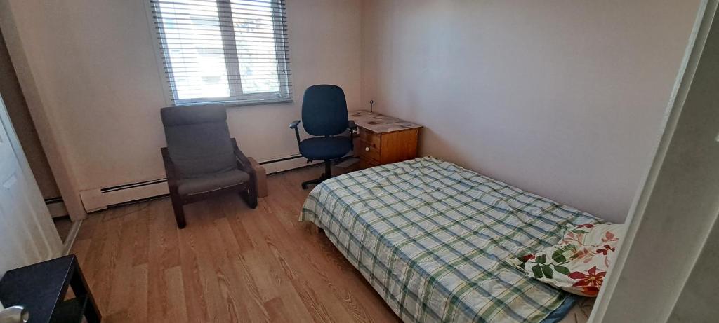 um quarto com uma cama, uma secretária e uma cadeira em W.R.M em Calgary