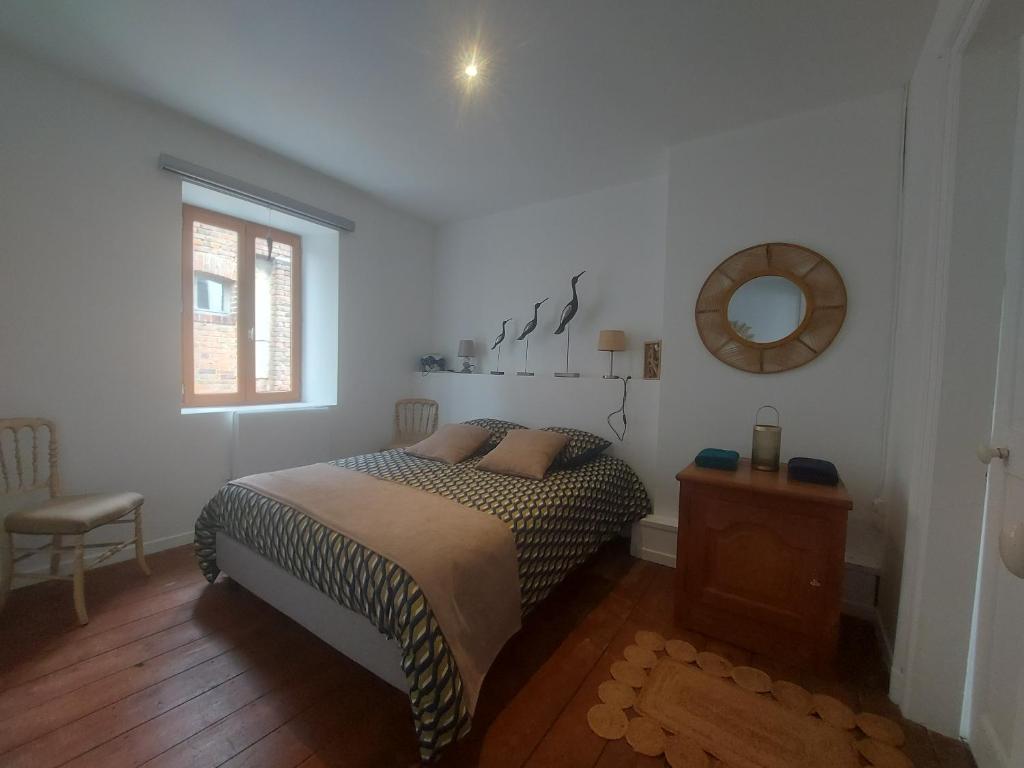 a bedroom with a bed and a mirror on the wall at Maison avec 4 chambres au centre de st Valéry in Saint-Valéry-sur-Somme