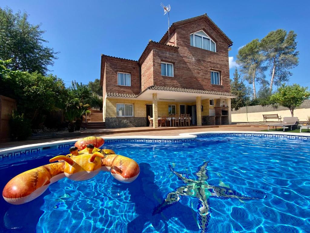 una casa con piscina frente a una casa en California House in Canyelles by HLCLUB Agency, en Canyelles