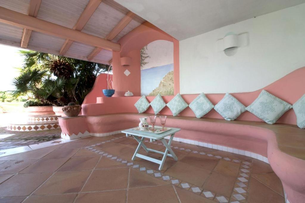 a room with a table and a pink wall at Residence Baja Sardinia in Baja Sardinia