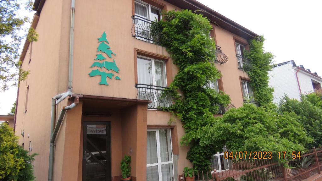 un edificio con un árbol de Navidad a su lado en O. W. Jodełka, en Łeba