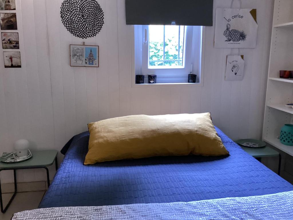 a bedroom with a blue bed and a window at Maisonnette Nantes in Nantes