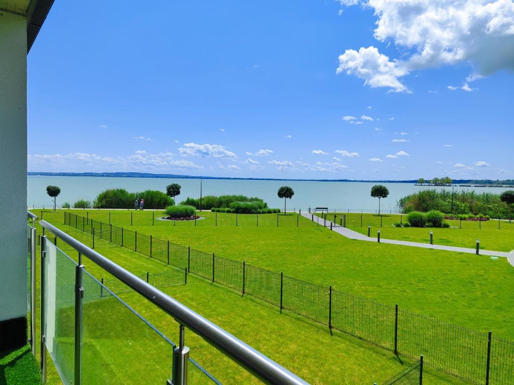 a view of a field of grass next to the water at Royal Liberty Apartment in Keszthely