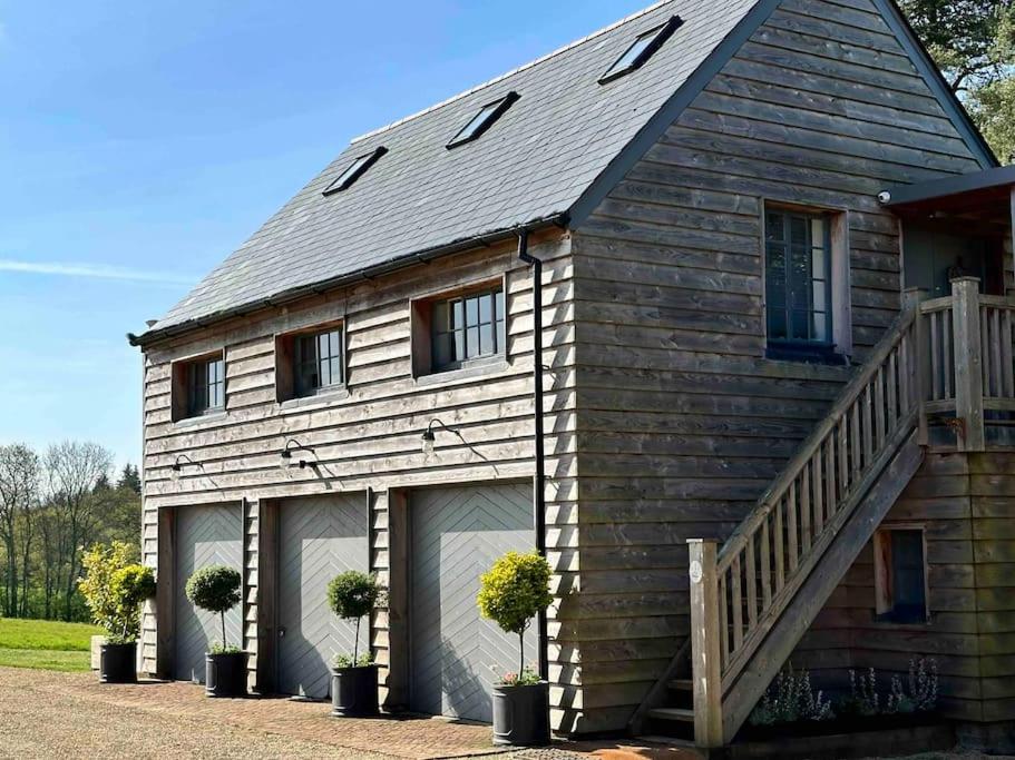 a house with two garage doors and a staircase at The Coach House in Shootend