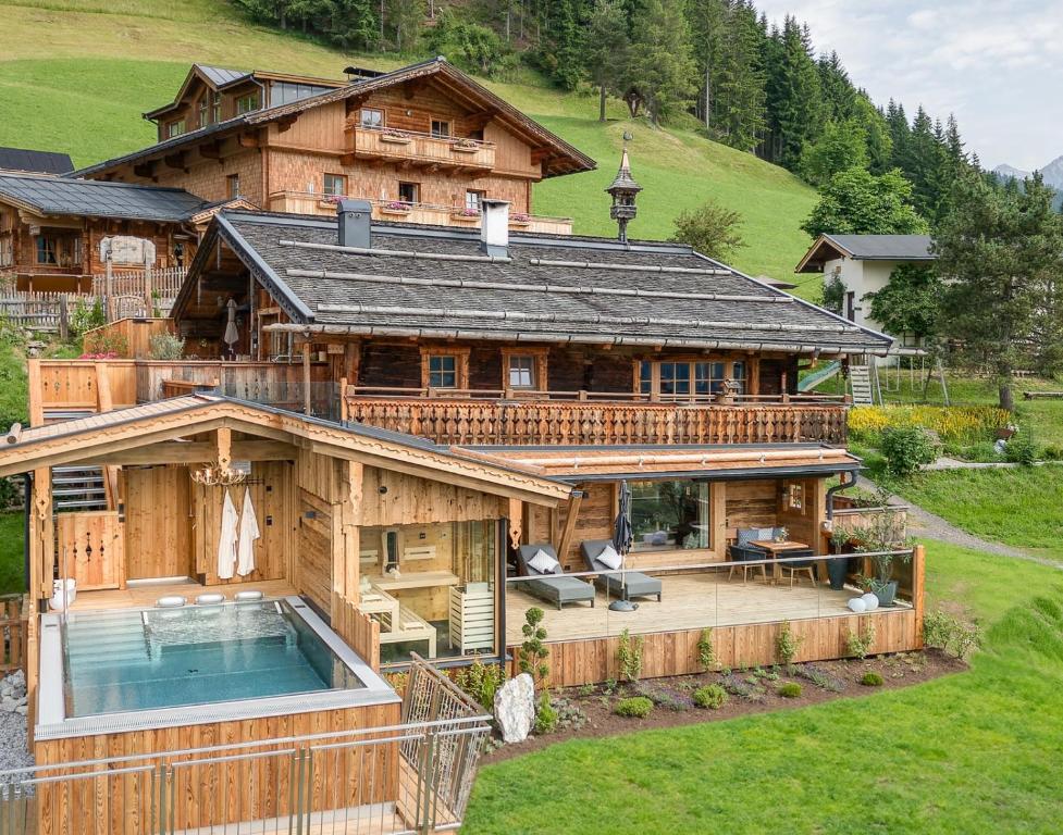 an aerial view of a large wooden house with a pool at Highking Chalet Grünegg in Dienten am Hochkönig