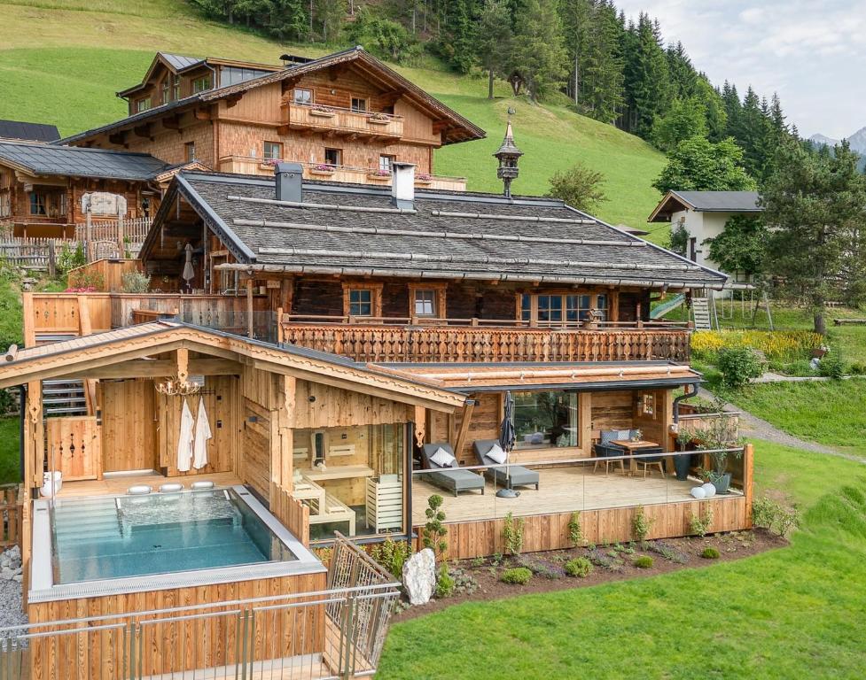 einen Luftblick auf ein großes Holzhaus mit einem Pool in der Unterkunft Highking Chalet Grünegg in Dienten am Hochkönig