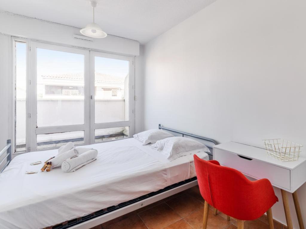een slaapkamer met een bed, een bureau en een rode stoel bij Chambres à louer dans appartement in Montpellier