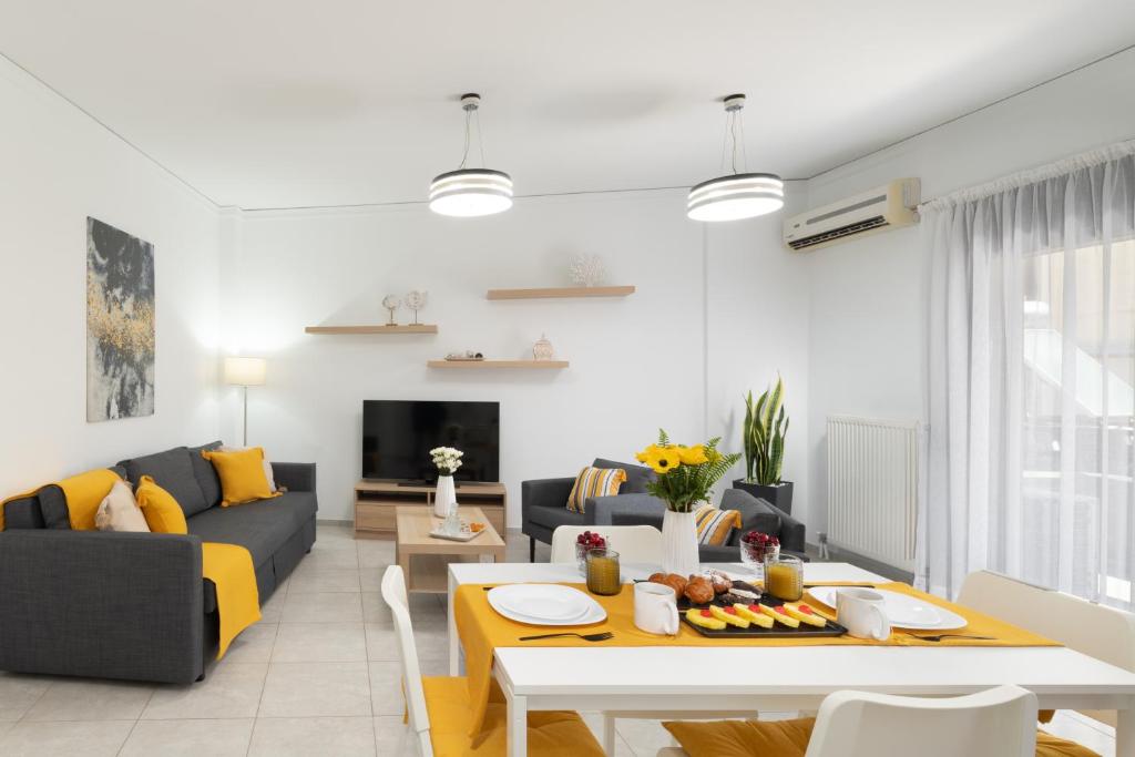 ein Wohnzimmer mit einem Sofa und einem Tisch in der Unterkunft Korai City Vibes in Iraklio
