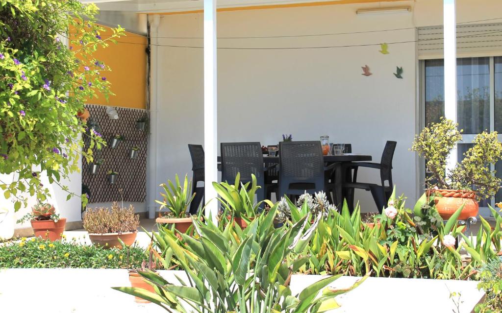 um pátio com uma mesa, cadeiras e plantas em Casa do Limoeiro em Albufeira