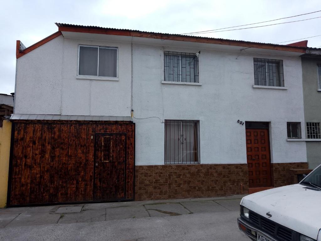 una casa blanca con una puerta y una valla en sleep easy, en Coquimbo