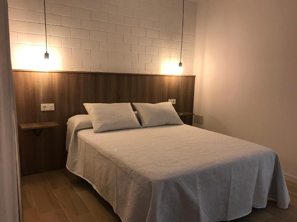 Trasariz Suites 1 في Vimianzo: غرفة نوم عليها سرير ووسادتين