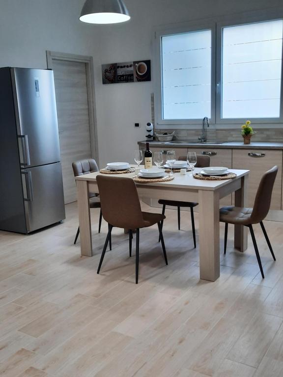 een keuken met een tafel, stoelen en een koelkast bij Holiday Home Dolia Center in Dolianova