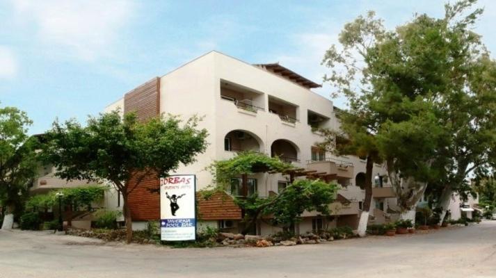 a large white building with a sign in front of it at Zorbas Hotel in Georgioupolis