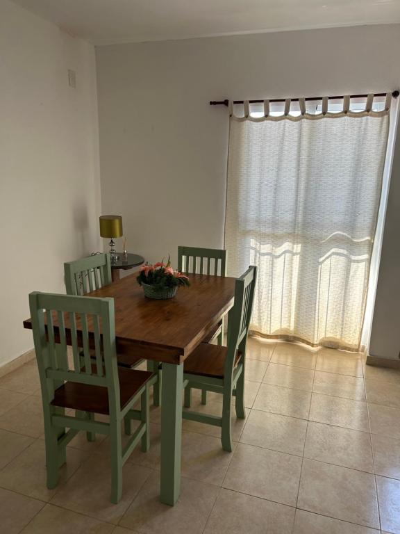 a dining room table with chairs and a bowl of flowers on it at Aires del estero 2 in Santiago del Estero