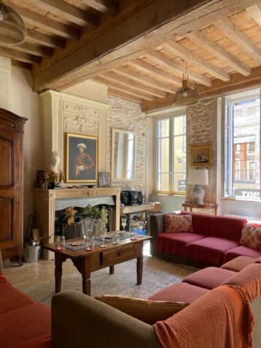 un salon avec un canapé et une table dans l'établissement La maison de Lea, chambres d'hôtes de 14 couchages, à Tournus