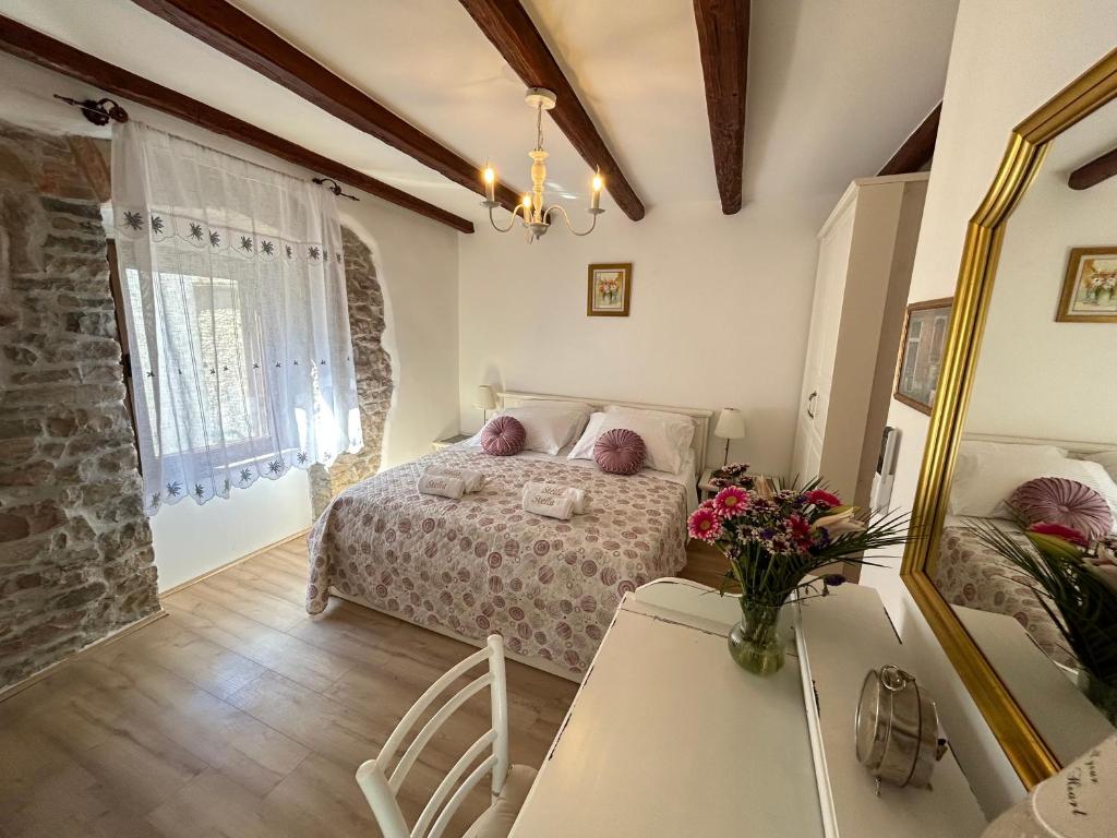 a bedroom with a bed and a table and a mirror at Casa Stella in Draguć