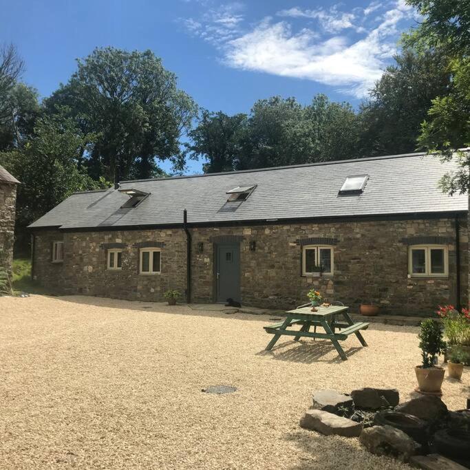 a brick building with a picnic table in front of it at Crymlyn barn in Llanwrda