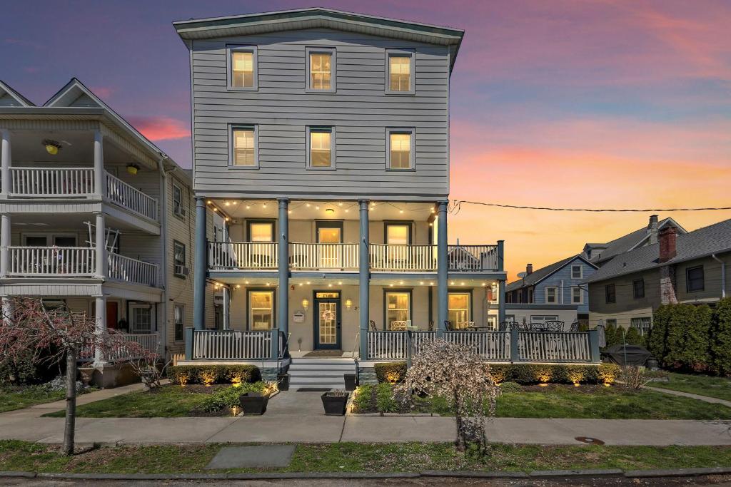 a large gray house with a sunset in the background at The Inn at Ocean Grove in Ocean Grove