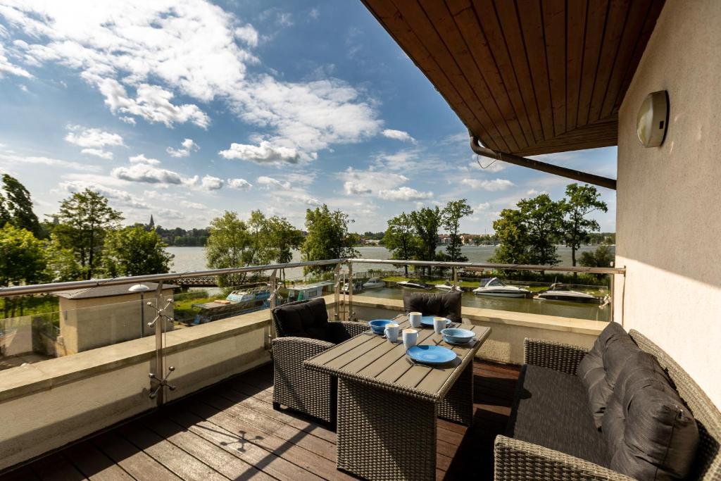オストルダにあるRezydencje Willa Port Apartamenty Antinoriの川の景色を望むバルコニー(テーブル、椅子付)
