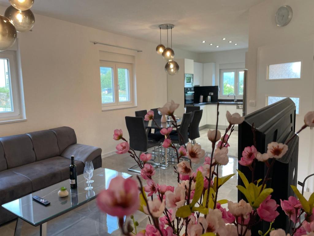 a living room with a table with flowers on it at Apartman Jurišić in Posušje