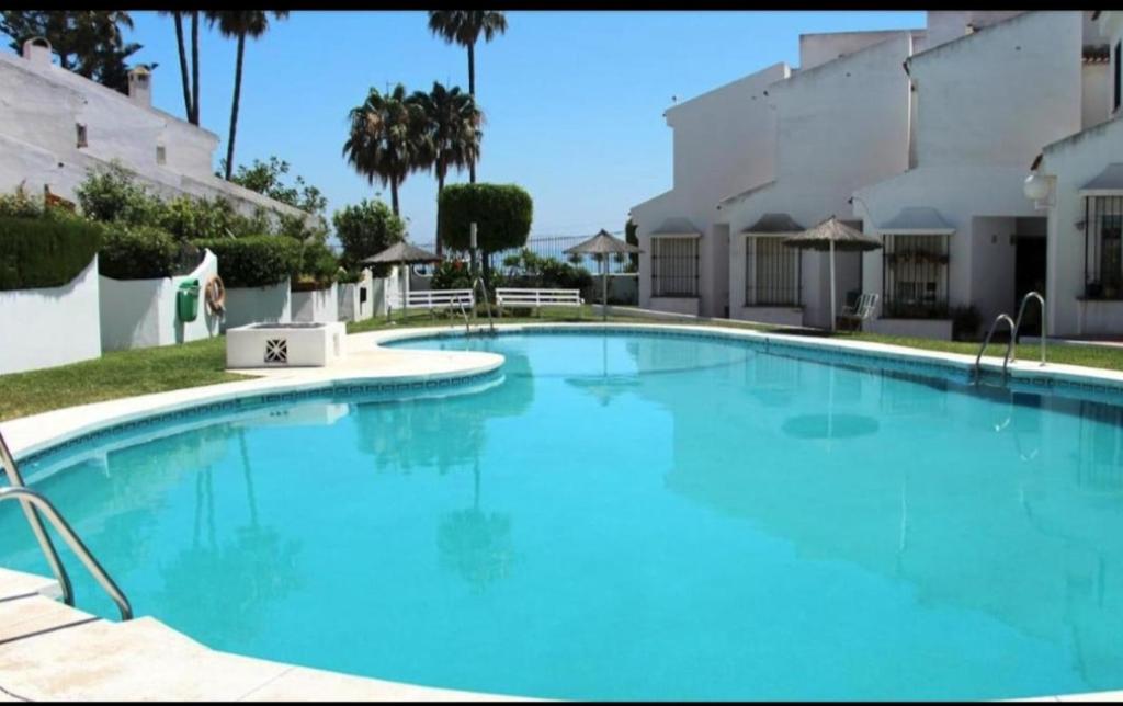 una gran piscina de agua azul frente a un edificio en Chalet Chilches Costa 1ª linea PLAYA, en Vélez-Málaga