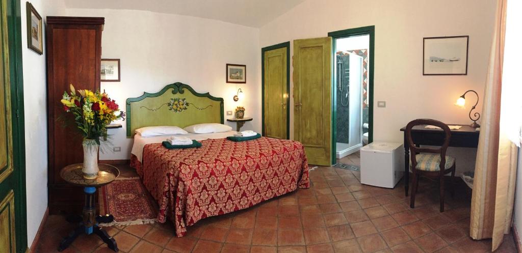 ジャルディーニ・ナクソスにあるB&B Terre Di Siciliaのベッドルーム1室(ベッド1台、花瓶1本付)