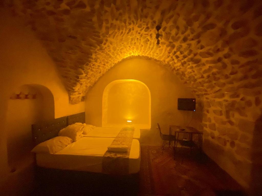 1 dormitorio con cama y pared de piedra en Gılgamesh butik otel en Mardin