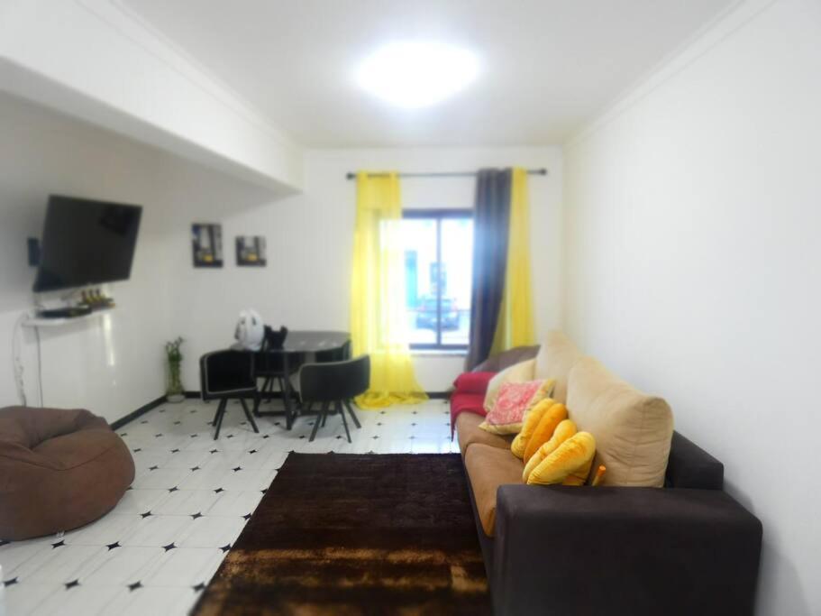 ein Wohnzimmer mit einem Sofa und einem Tisch in der Unterkunft Apartamento Marisol Confort in Aroeira
