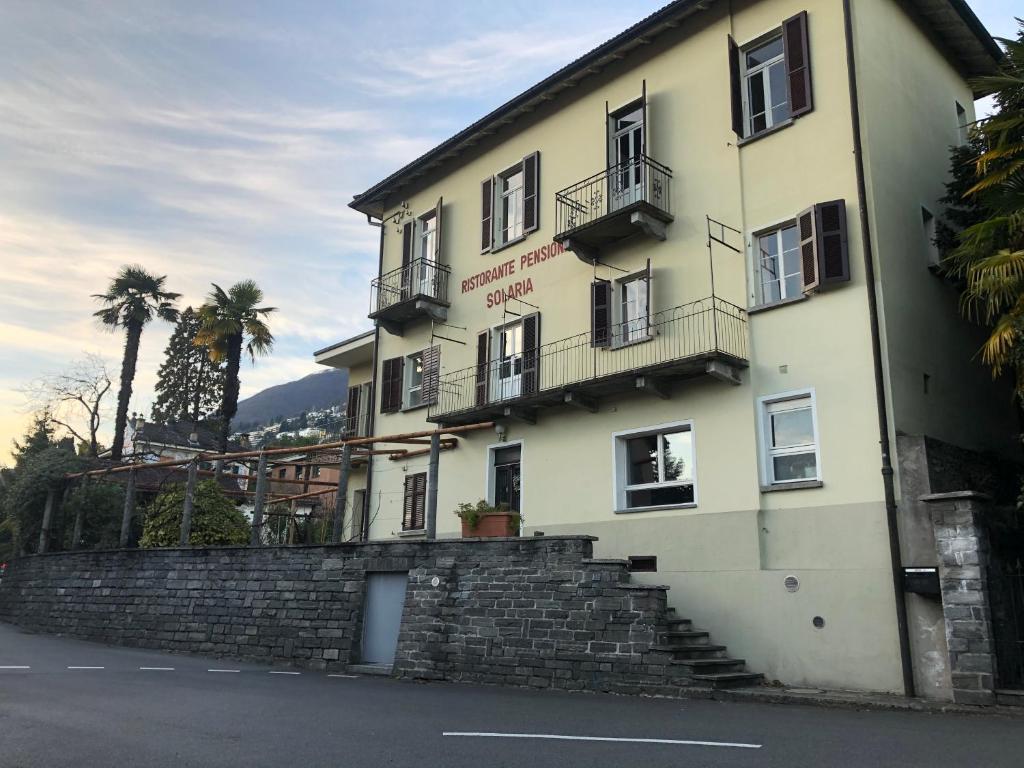 a building with a stone wall in front of it at Pensione Solaria in Locarno