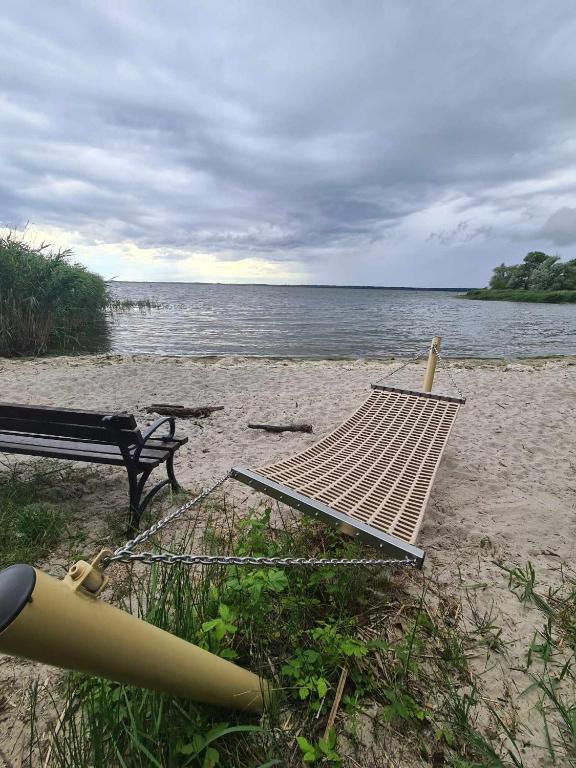 a picnic table and a bench on a beach at Domki Przy Marinie Wapnica 6 km od Międzyzdrojów in Wapnica