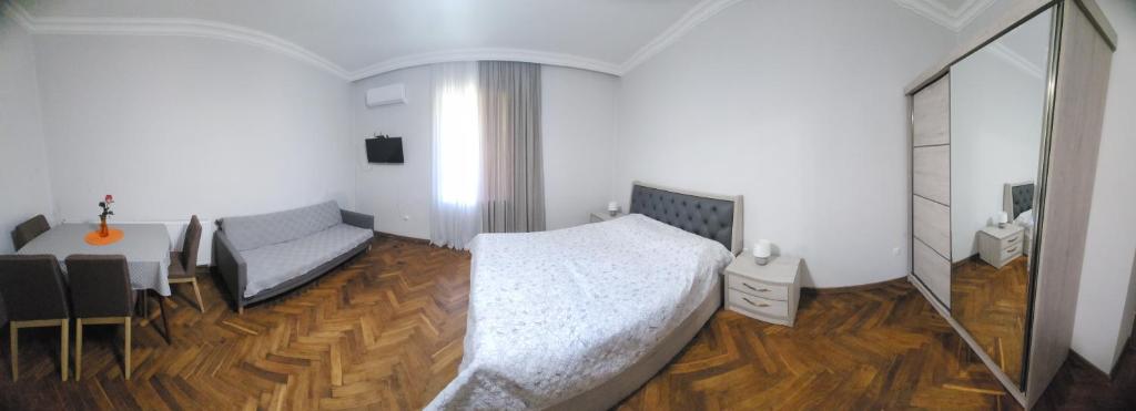 1 dormitorio con cama, escritorio y espejo en Comfortable Apartment close to Central Park en Tskaltubo