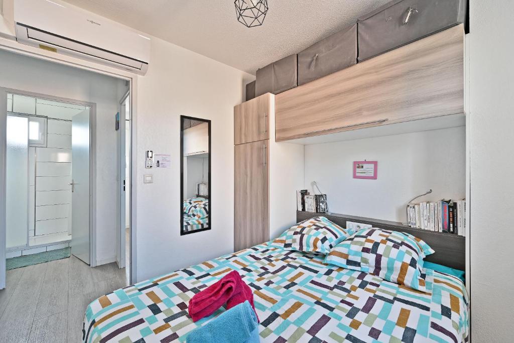sypialnia z łóżkiem z drewnianym zagłówkiem w obiekcie LE PETIT BONHEUR - PLACE PARKING PRIVEE - CLiM - TERRASSE - PISCINE PARTAGEE - PROCHE PARC SPIROU w mieście Saint-Saturnin-les-Avignon