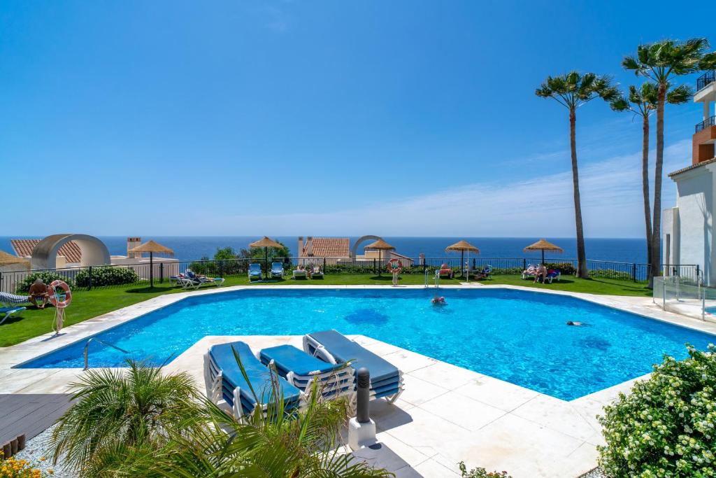 托羅克斯科斯塔的住宿－Calaceite 3121 Ocean Paradise Casasol，一个带椅子的游泳池,背景是大海