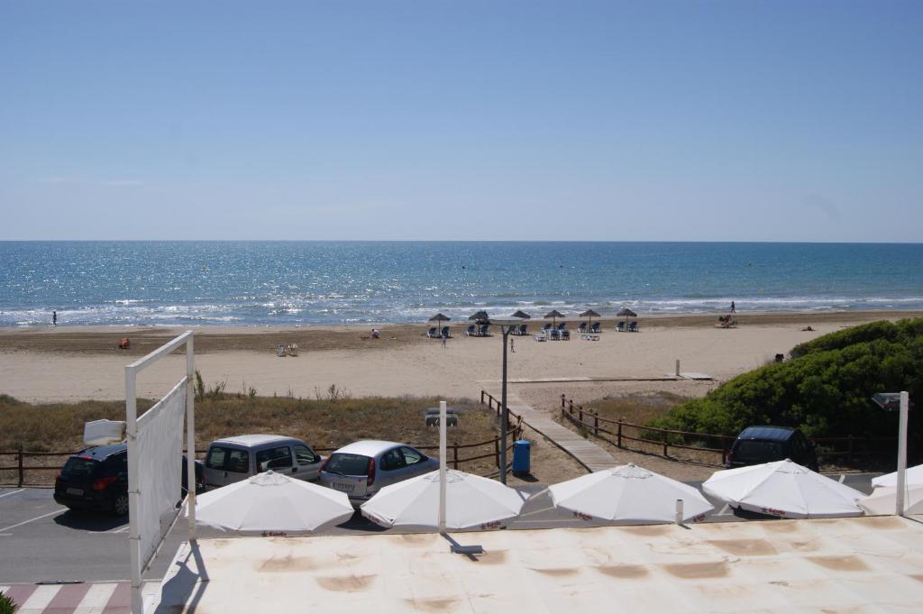 uma praia com um monte de carros estacionados e o oceano em Apartamentos Playa Cargador em Alcossebre