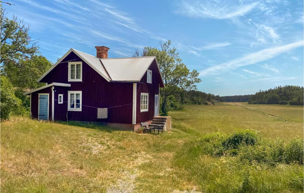ein rotes Haus auf einem Hügel auf einem Feld in der Unterkunft 2 Bedroom Amazing Home In Figeholm in Figeholm