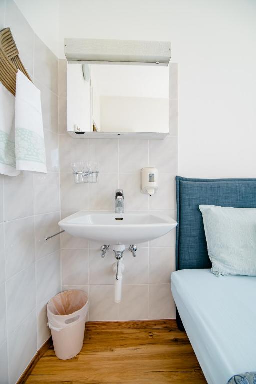 a bathroom with a sink and a bed at Pensione Solaria in Locarno