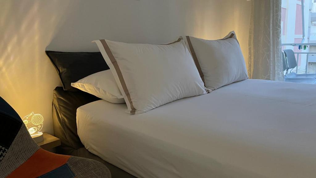 1 dormitorio con 1 cama con almohadas blancas en Alfa home en Atenas