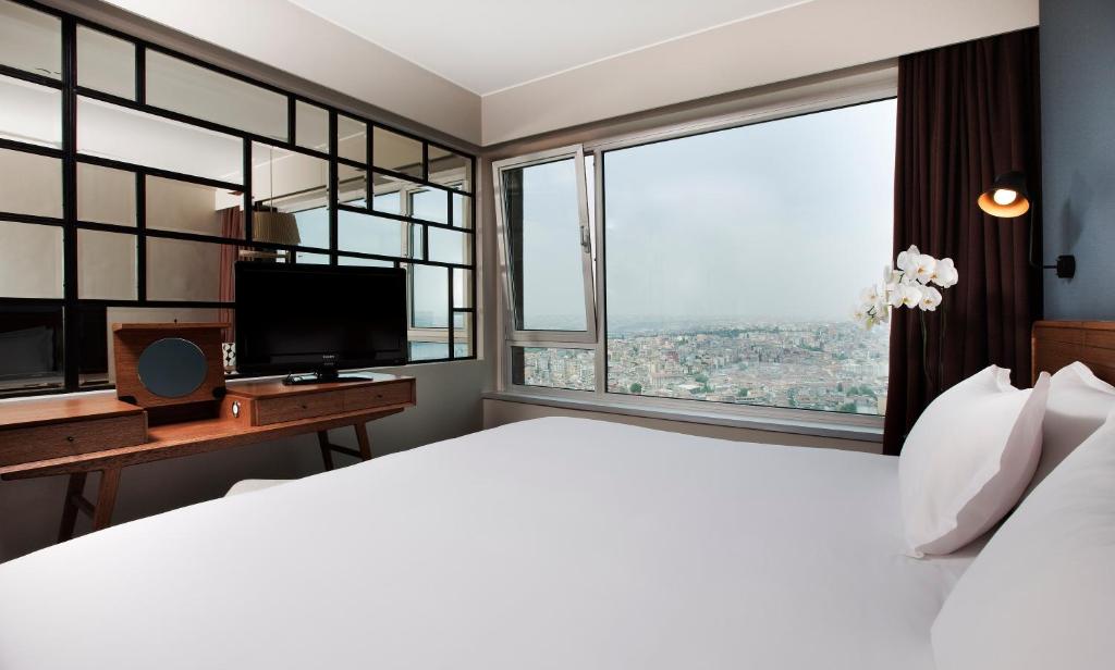 a bedroom with a large bed and a large window at The Marmara Pera in Istanbul