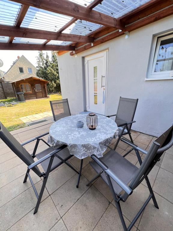 une table et quatre chaises sur la terrasse dans l'établissement Ferienhaus Feldblick, à Greifswald