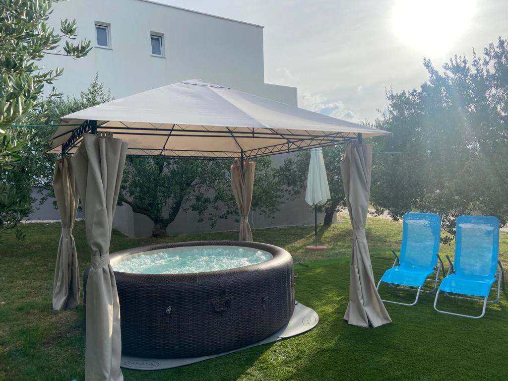 a gazebo with two chairs and a swimming pool at Holiday home " MIA" in Gradina