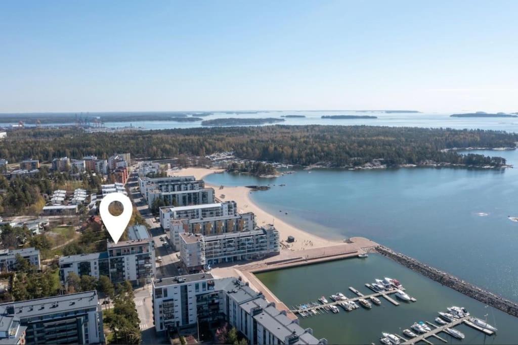 een luchtzicht op een strand en een waterlichaam bij Meren läheisyydessä iso yksiö in Helsinki