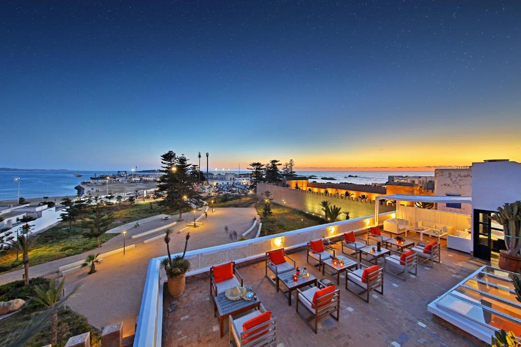 索維拉的住宿－馬達達莫加多酒店，阳台配有桌椅,俯瞰着海滩