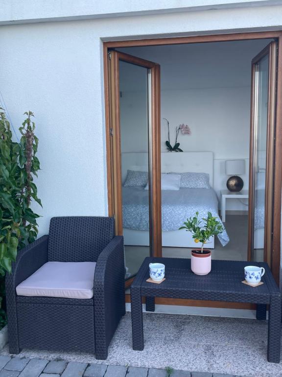 eine Terrasse mit einem Stuhl, einem Tisch und einem Bett in der Unterkunft Studio Apartman Lana 3 in Ičići