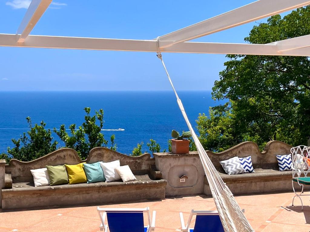 un divano con cuscini su un patio con vista sull'oceano di Nira - Smart & Luxury Home a Praiano