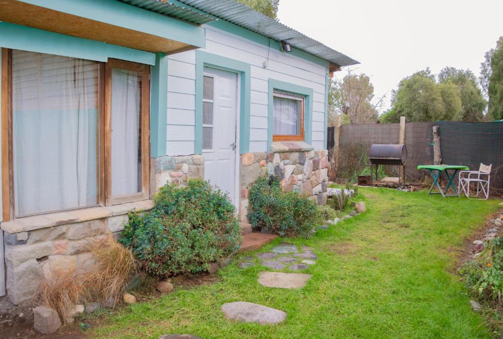 una casa azul con una pared de piedra y un patio en La serena en San Carlos de Bariloche