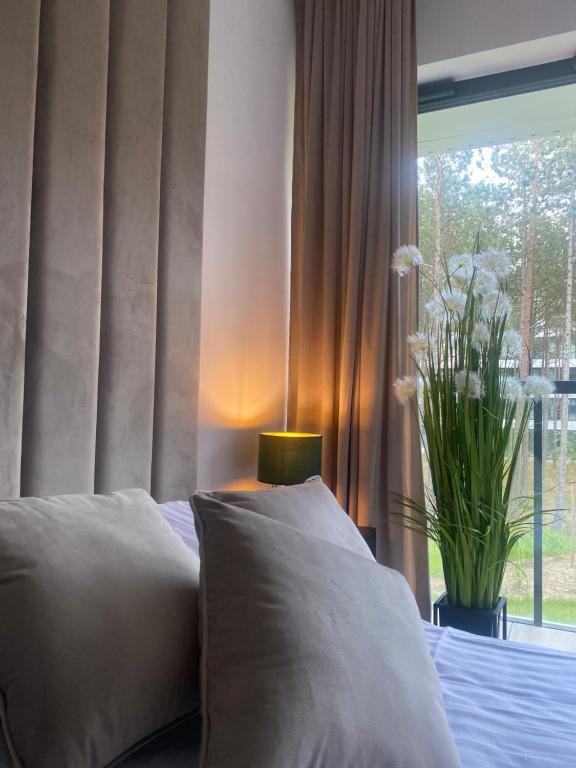 a bedroom with a bed with pillows and a window at Seaside Shellter Rogowo in Rogowo