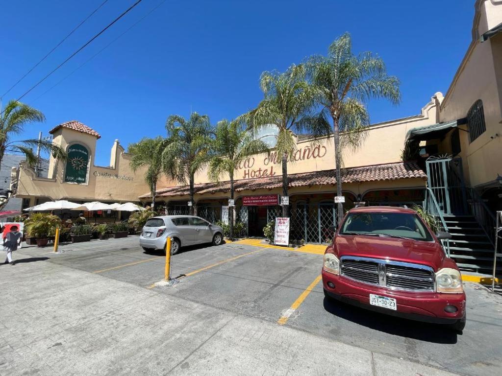 un coche rojo estacionado en un estacionamiento frente a un edificio en Casita Montana Hotel en Ajijic