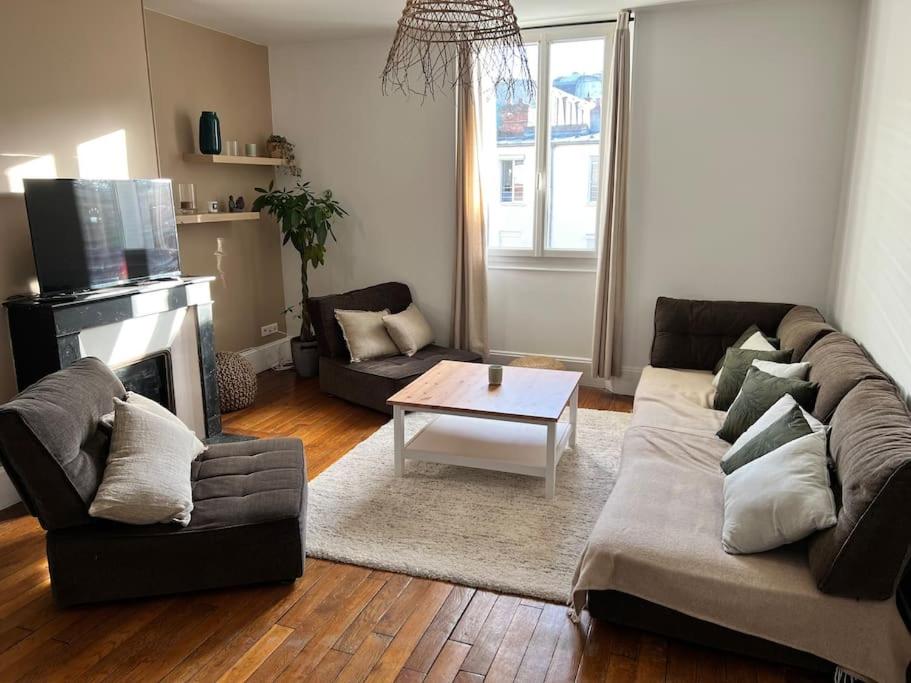 a living room with a couch and a coffee table at Superbe appartement avec cheminée in Fontainebleau