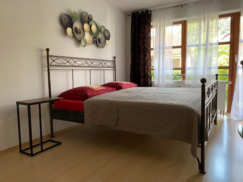 Schlafzimmer mit einem Bett mit roten Kissen und einem Fenster in der Unterkunft Ferienwohnung mit Terrasse Nähe Bayreuth in Heinersreuth