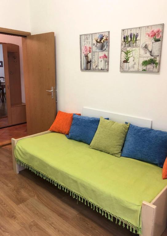 una cama con almohadas coloridas en una habitación en Vukčević apartman, en Sutomore